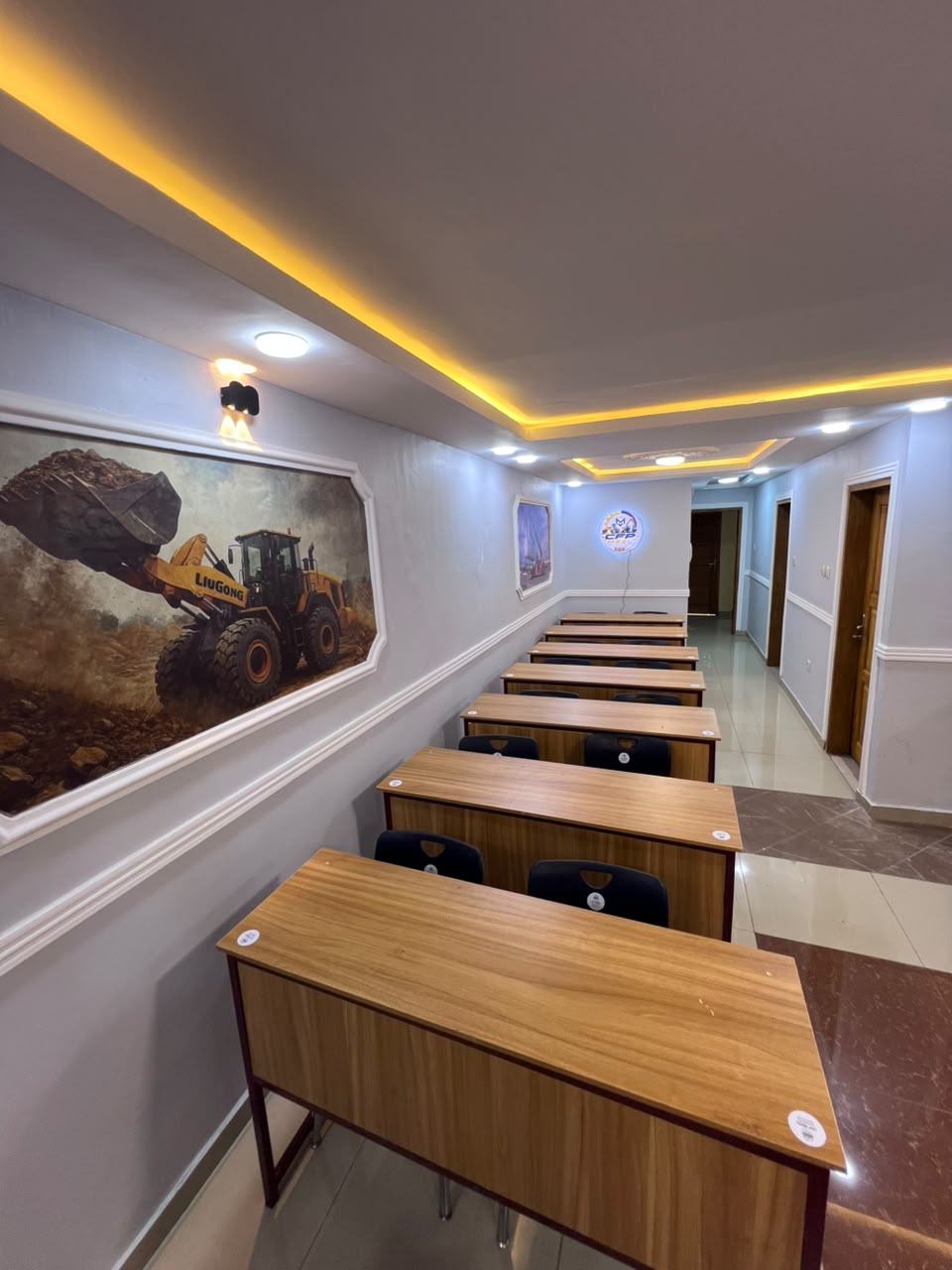 Salle de cours CFPMEEL climatisée avec tableaux d'engins et enseigne lumineuse