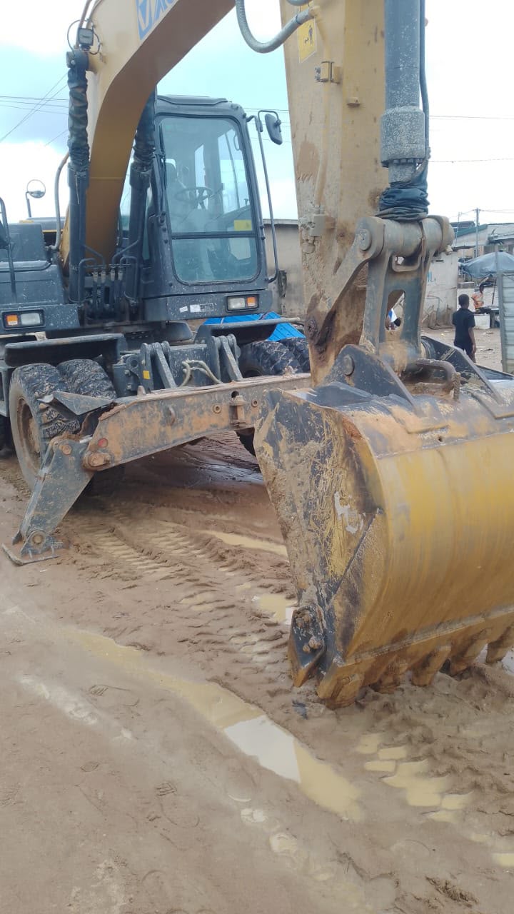 Pelle sur pneus et godet en travaux de terrassement sur terrain boueux