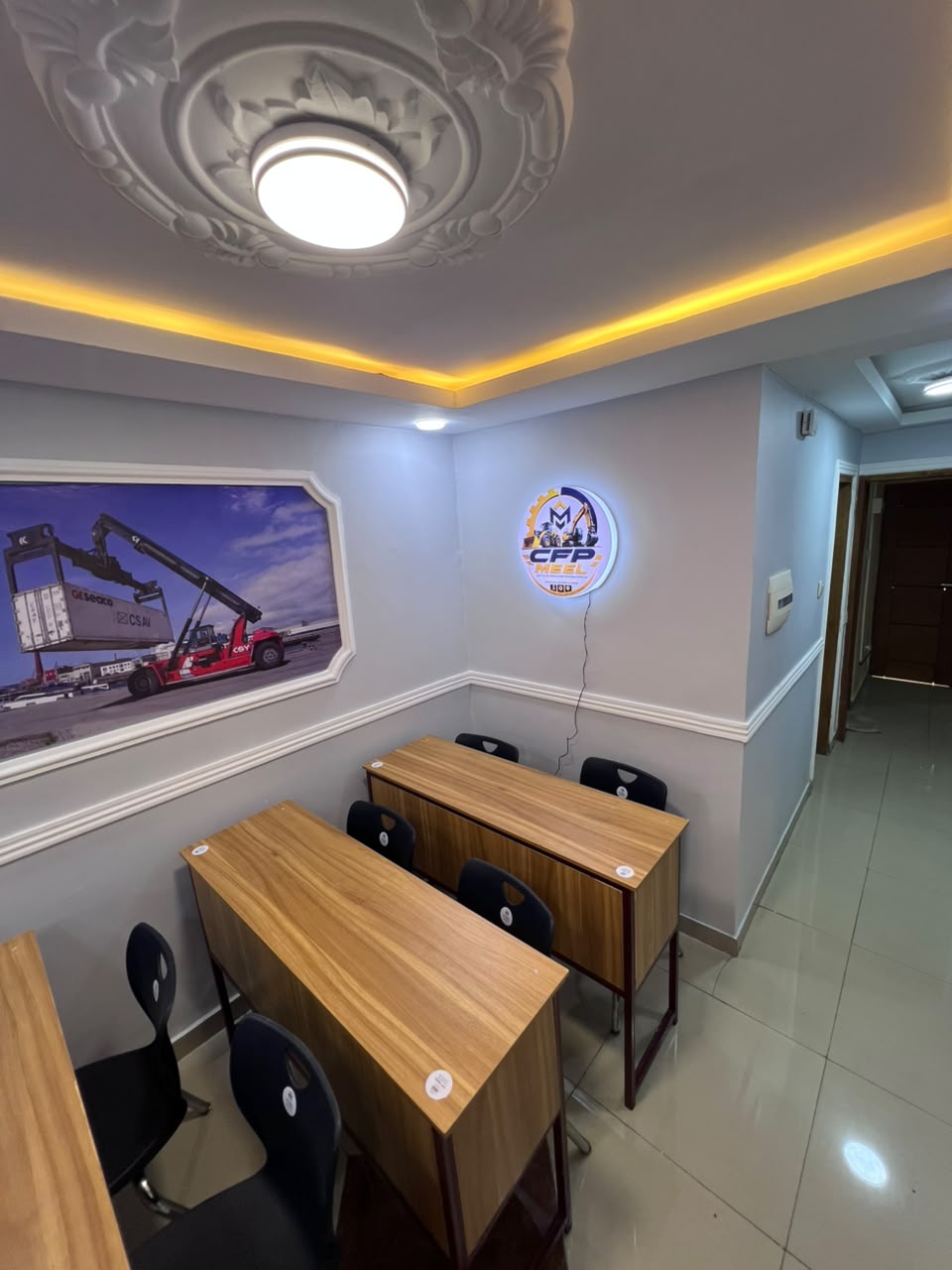 Salle de cours avec visuel de reach stacker et enseigne CFPMEEL rétroéclairée