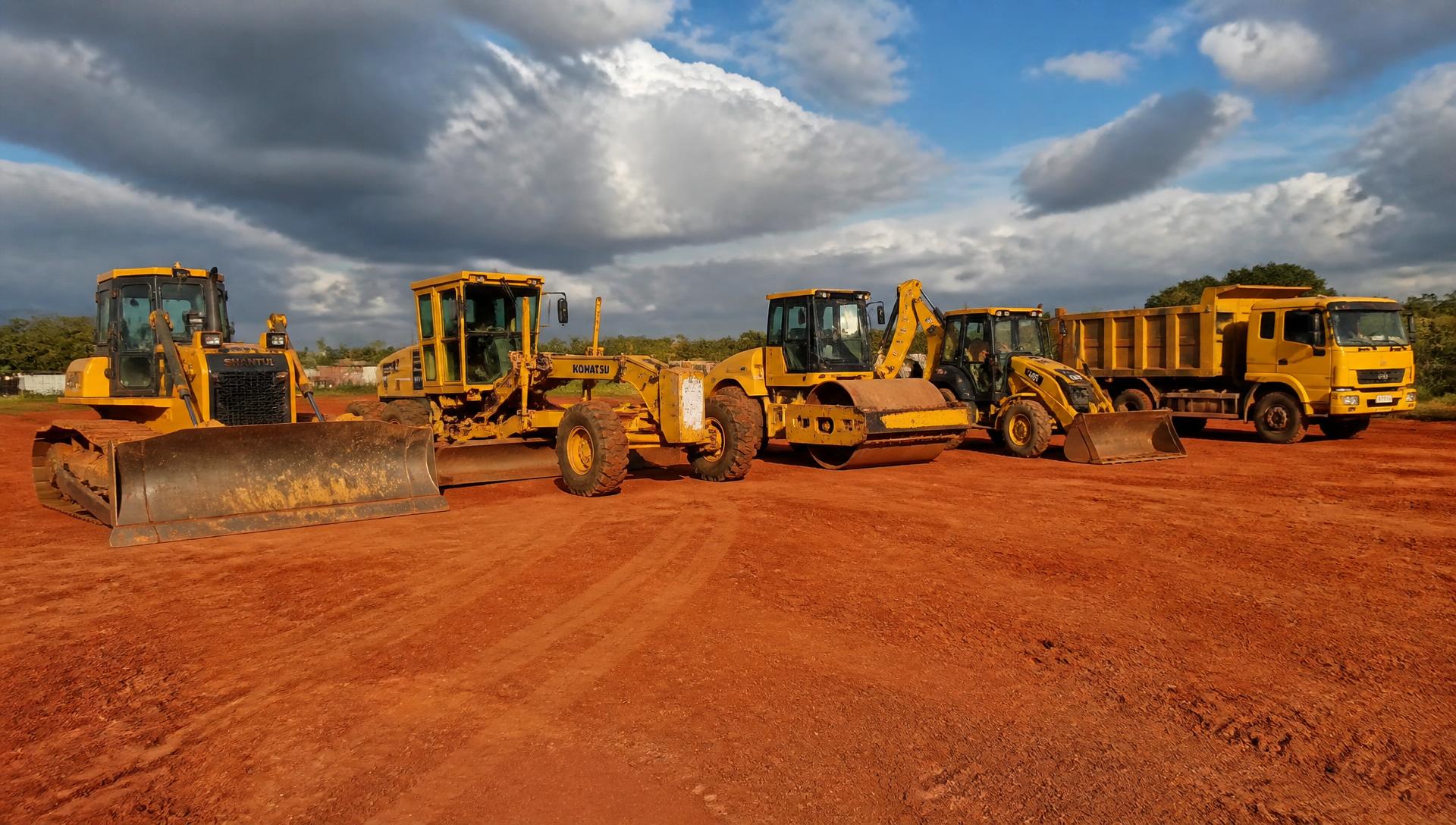 Parc d'engins CFPMEEL : bulldozer, niveleuse, compacteur, tractopelle et camion benne alignés